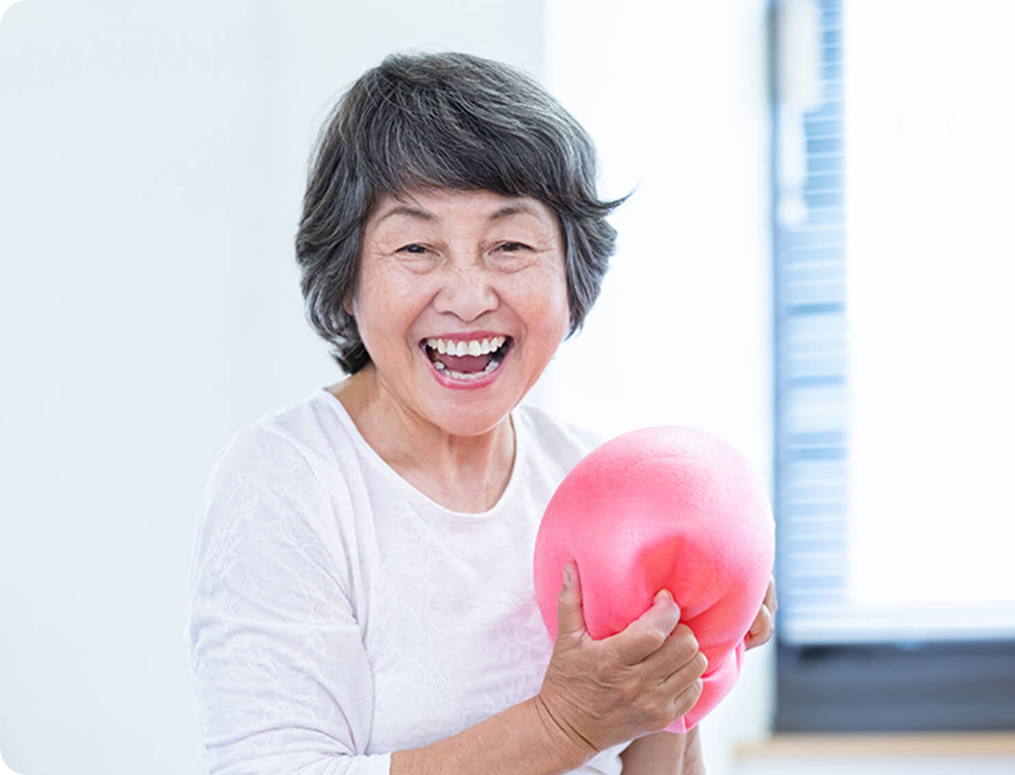 トレーニングボールをもっている笑顔の高齢女性